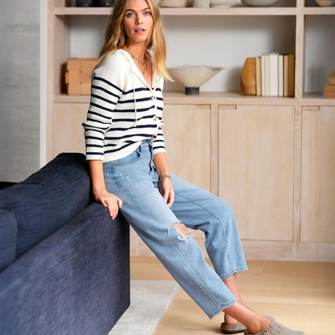 A capsule wardrobe essential featuring a striped button-down sweater paired with relaxed-fit jeans, demonstrating versatile capsule wardrobe styling