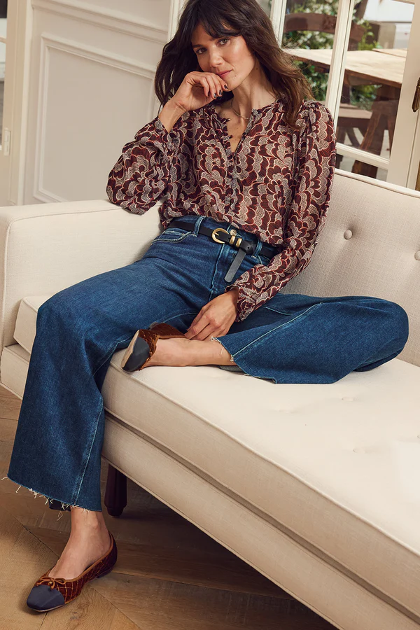 A feminine floral blouse in burgundy tones paired with wide-leg jeans and ballet flats, demonstrating what to wear for family photos with a casual yet polished look