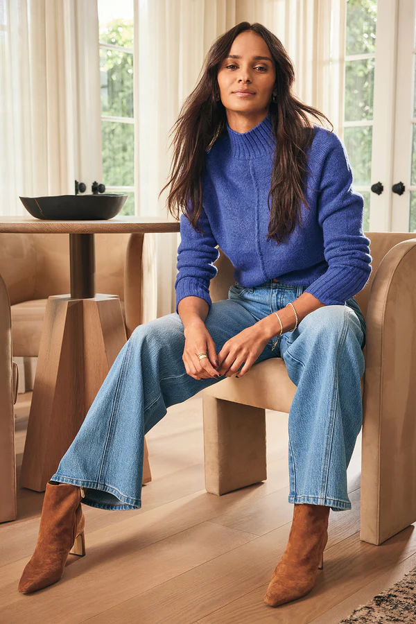 A cozy blue turtleneck sweater styled with wide-leg jeans and brown boots, showing what to wear for family photos in a casual fall setting