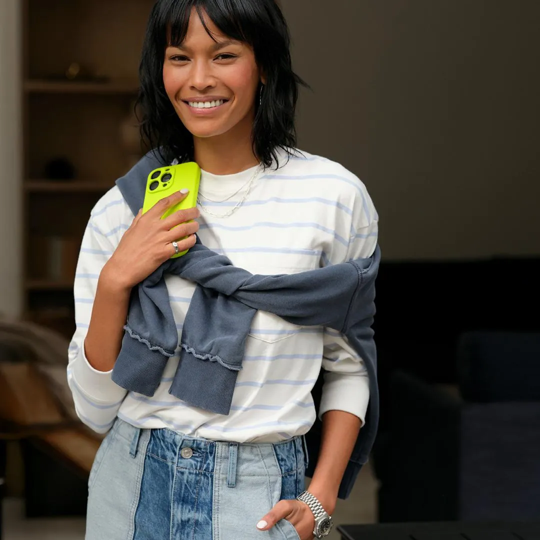 A jeans and a sweatshirt outfit featuring a white and blue striped sweatshirt paired with light wash denim, showing how to style a casual yet polished look