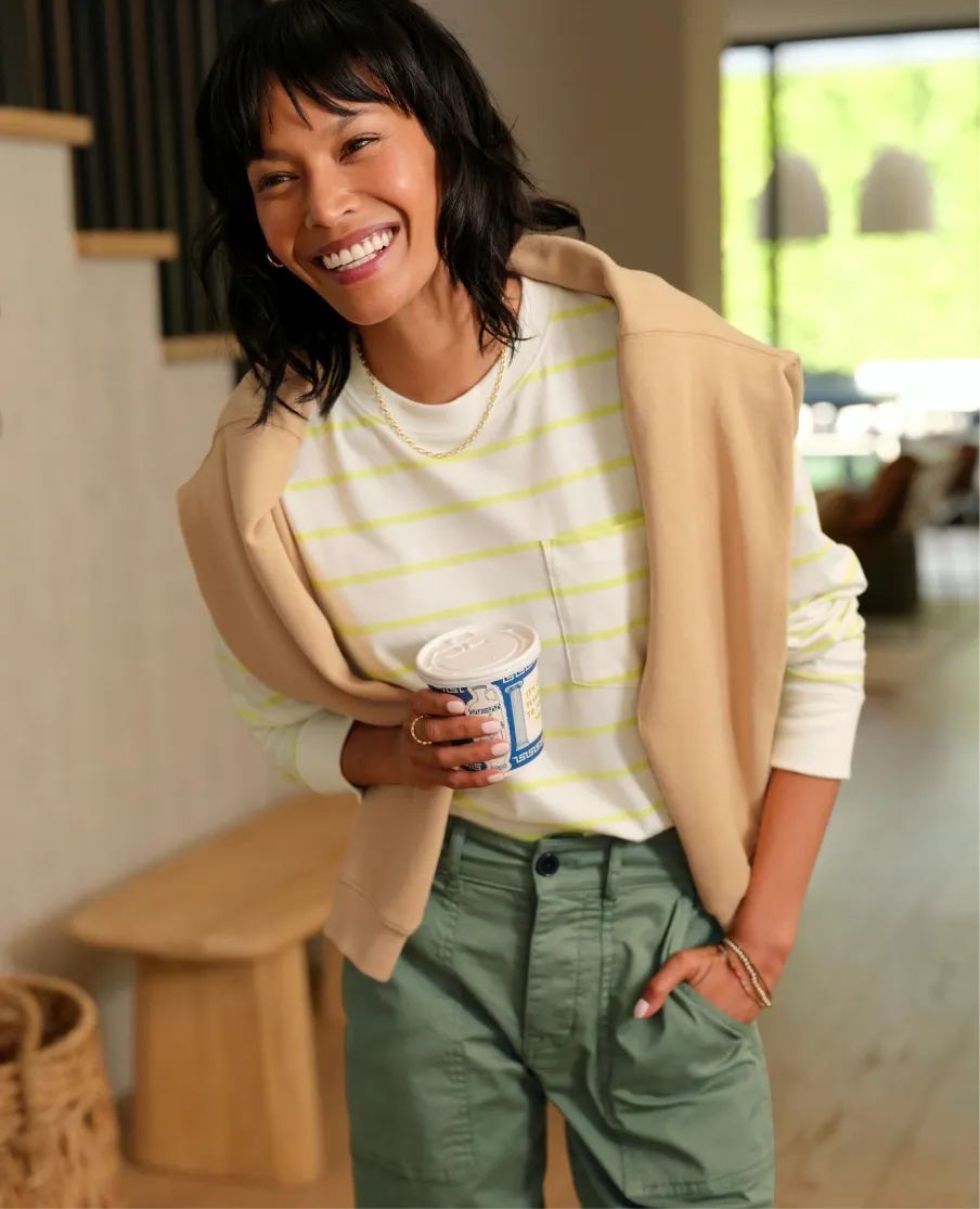 How to wear yellow demonstrated with a white and yellow striped sweater paired with olive cargo pants and a sweater, showing how to style subtle yellow stripes for everyday wear